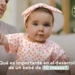 niña bebé de 10 meses con vestido blanco con flores naranjas